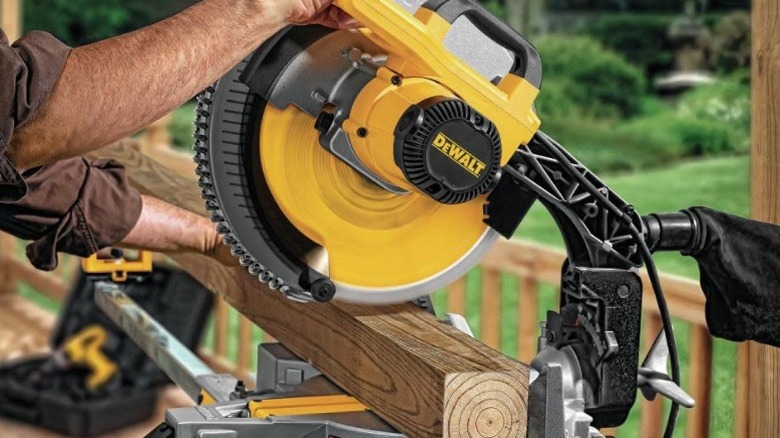 Peron using miter saw on 4x4