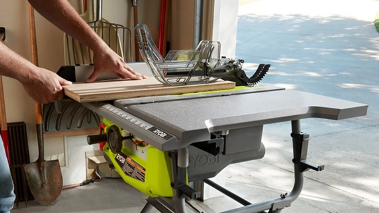 Person cutting board on table saw