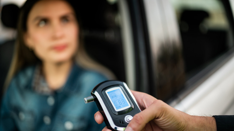 Police officer looking at breathalyzer