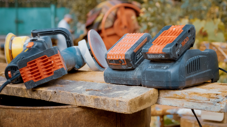 A selection of power tool batteries charging on a workbench