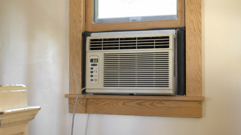 An air conditioning unit in a window with a wooden frame