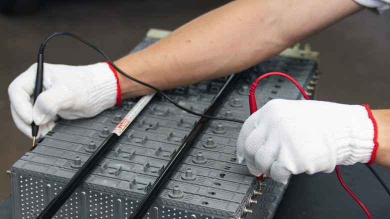 Serviceman repairs electric battery pack of hybrid car
