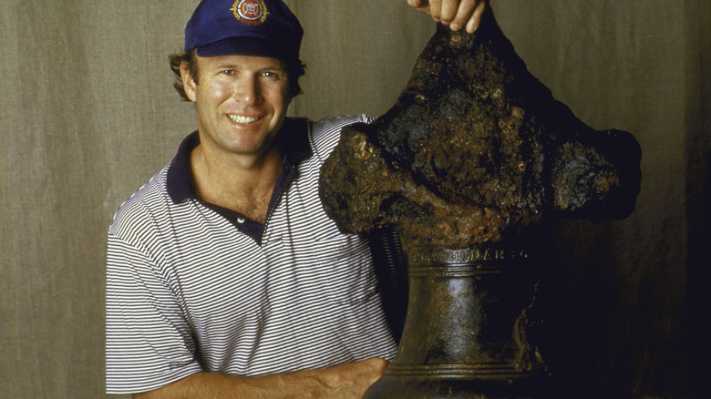man posing with Whydah's ship bell