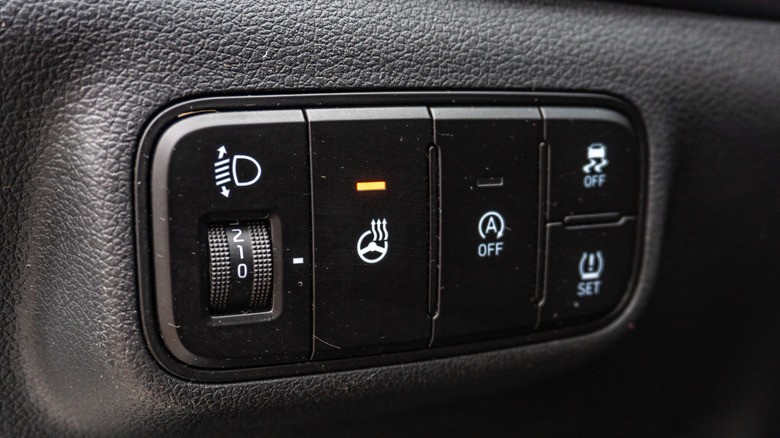 The heated steering wheel button on a control panel of an unidentified car