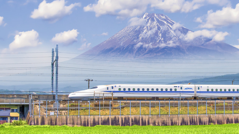 A Shinkansen bullet train passing by Mount Fuji in Japan.