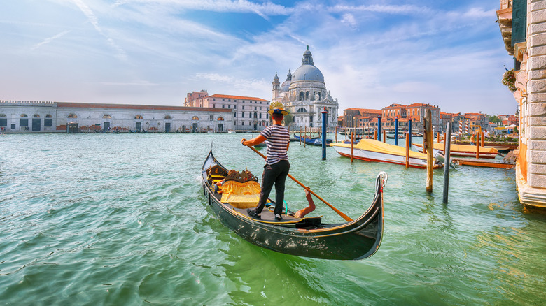 A gondolier rowing a gondola in Venice, Italy
