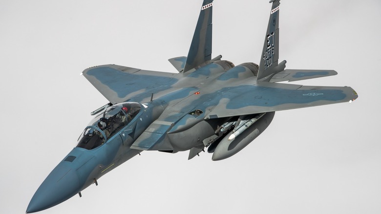An F-15EX Eagle II in flight over grey skies