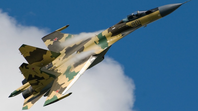 A Sukhoi Su-35 in flight over a cloud