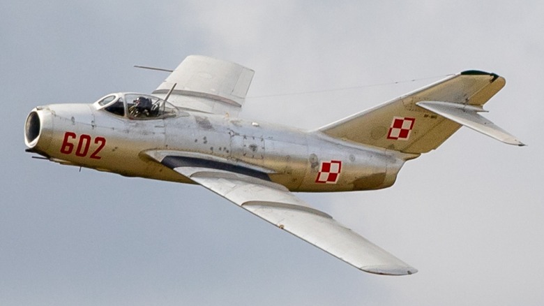 A MiG-15 flying over cloudy skies