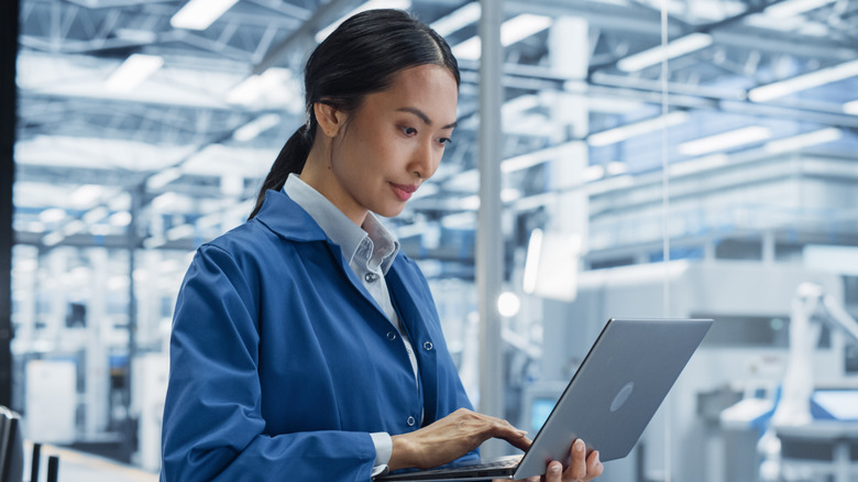 Woman with laptop in factory