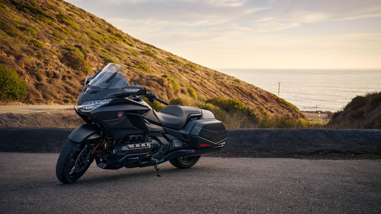 A black Honda Gold wing from the 2025 model year finished in black metallic paint, parked on a curving mountain road.