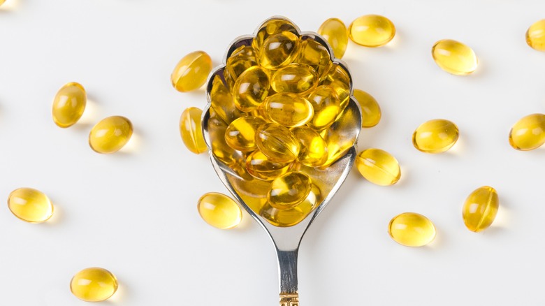 Vitamin capsules on a spoon
