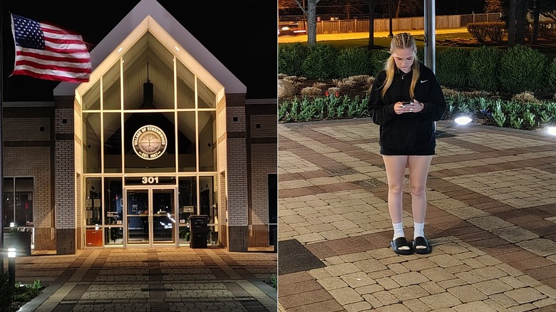 Photo of a building at night and a woman looking at her phone
