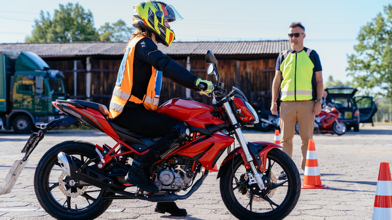 A Person Learning To Ride A Motorcycle With Instructor