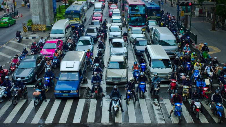 An image of many motorcyclists lane filtering at an intersection