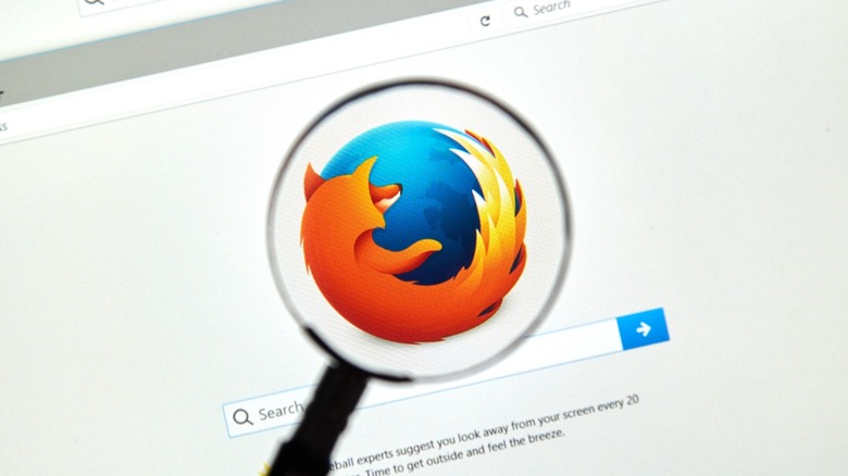 The Firefox logo on a browser screen under a magnifying glass