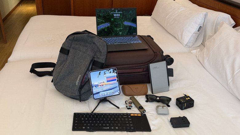 Multiple tech items on a bed.