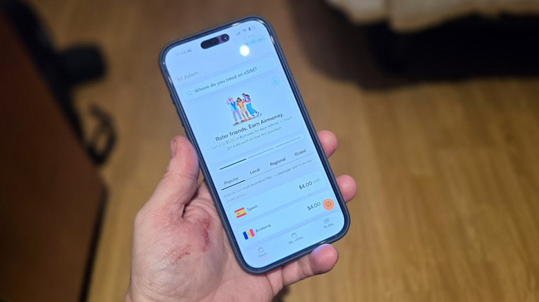Man holding an iPhone with the Airalo App open