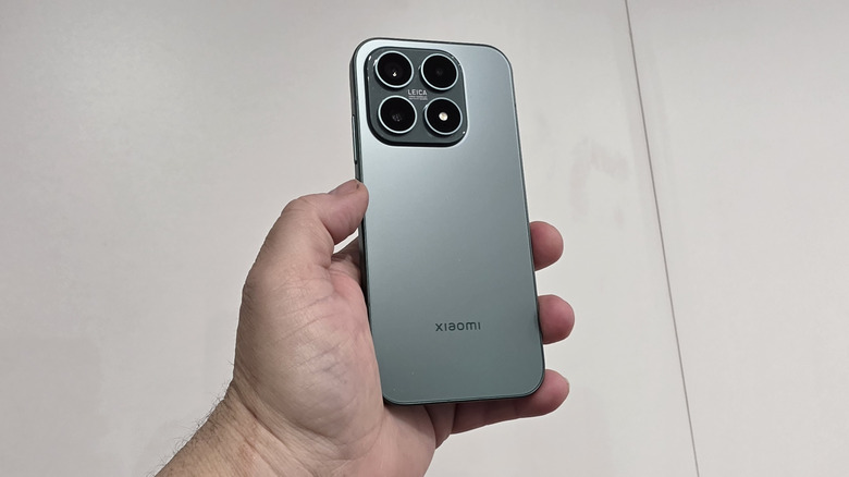 Hand holding a Xiaomi 17 in front of a white background