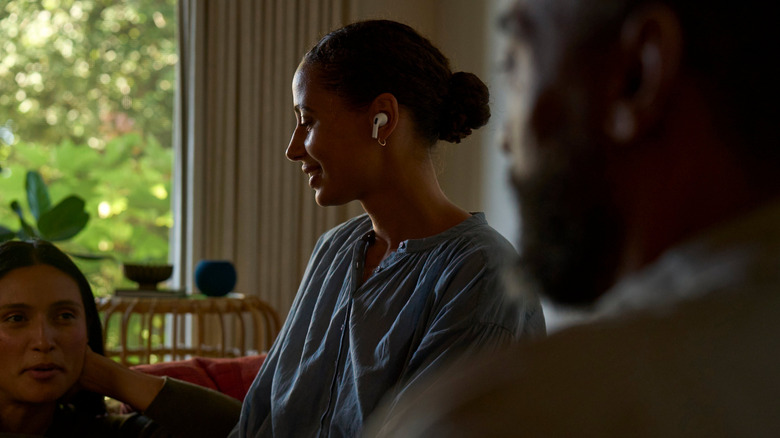 Woman wearing AirPods sits with friends