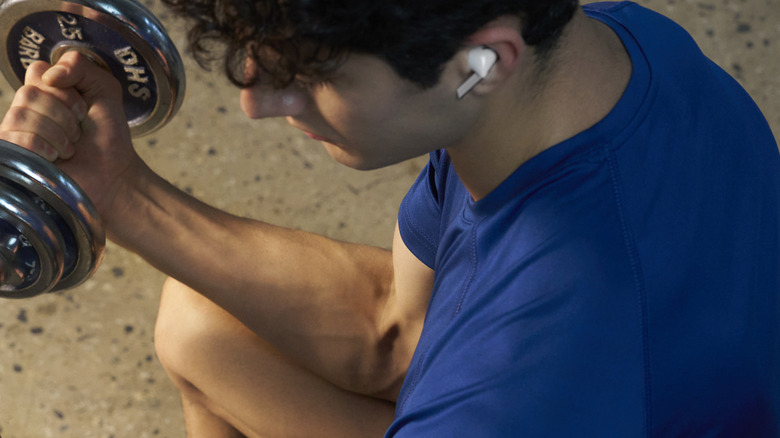 Man lifting weights while wearing Samsung Galaxy Buds3 Pro