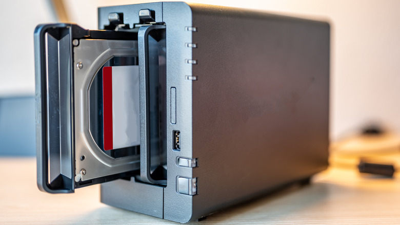 Close up view of NAS hardware with one bay open showing space for a HDD