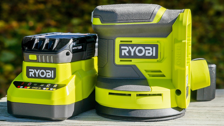 A close up of Ryobi power tool battery and a charger on a table