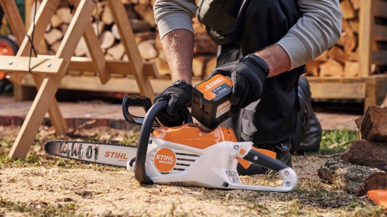 Person putting battery into a Stihl chainsaw
