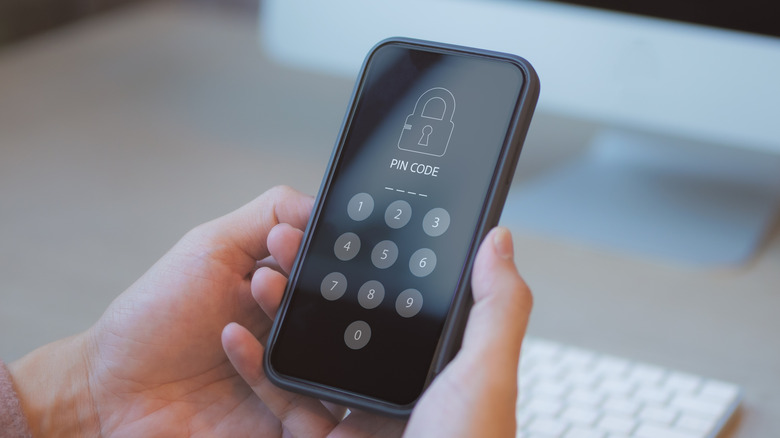 Close up of a person holding a phone asking for lock screen PIN