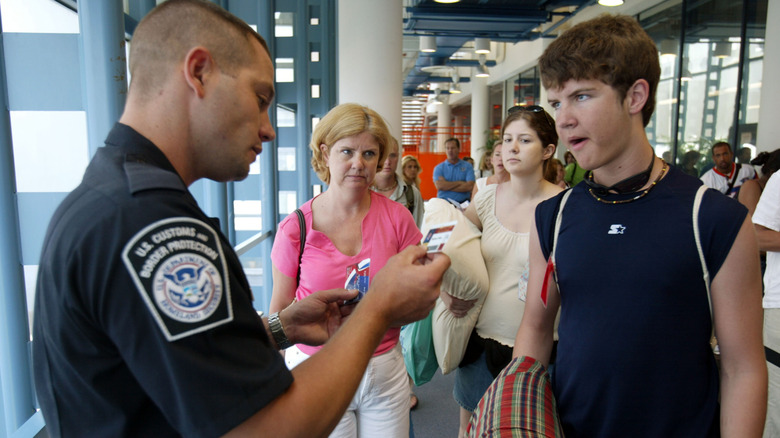 Customs and Border Protection officer looks at documents as he checks passengers arriving from cruise ships