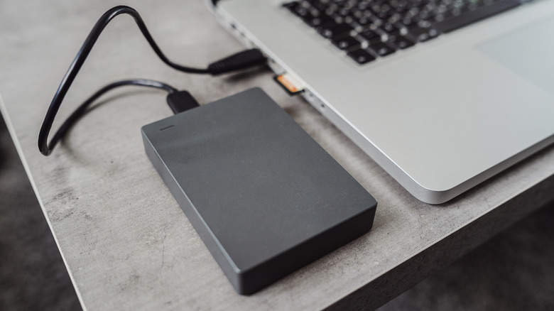 External hard disk drive connected to a modern laptop via USB