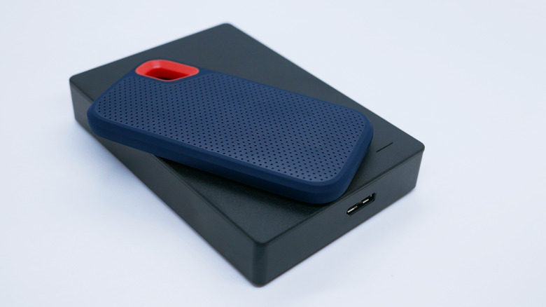 Close-up of two external hard drives - a compact SSD and a larger HDD