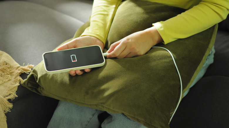 Woman hands Charging mobile phone battery with low battery.