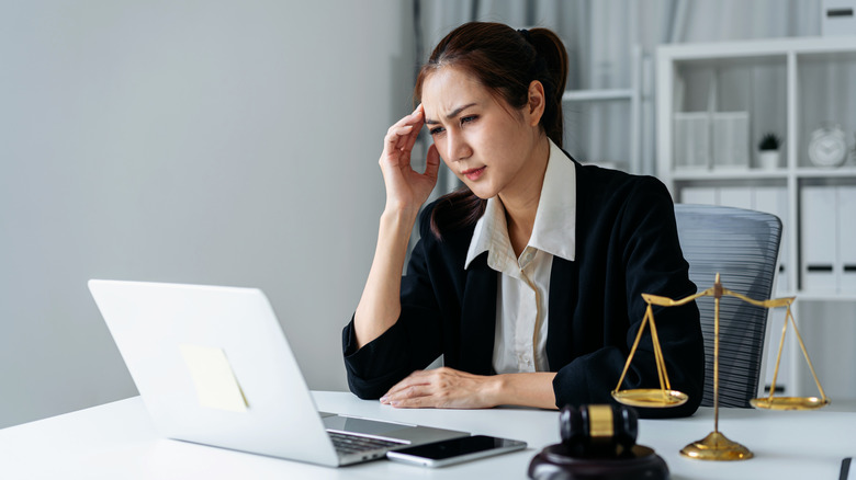 Woman looks concerned while using laptop