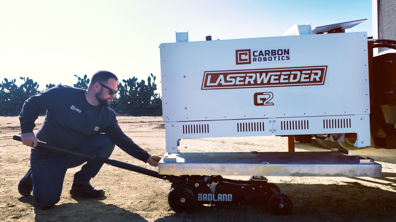 A person adjusting the Laserweeder G2 robot