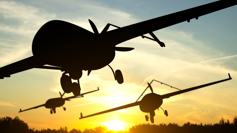 Silhouette of military combat drones against the sunset