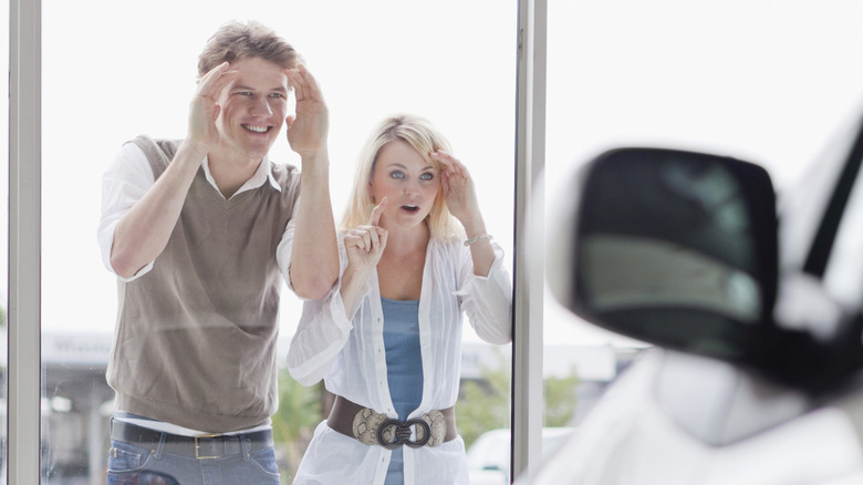 couple looking through dealership window