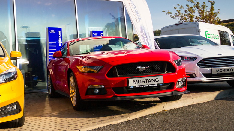 Three cars in front of a Ford dealership