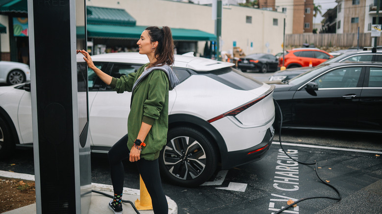Woman stops at ab EV charging station to charge her car