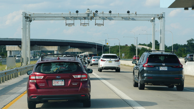 Cars driving through a highway toll scanner