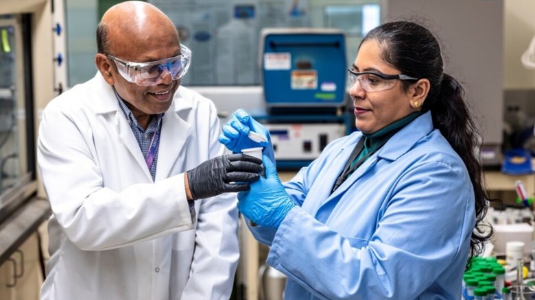 Two people preparing lithium brine and sorbent to initiate a hydrothermal reaction for lithium recovery