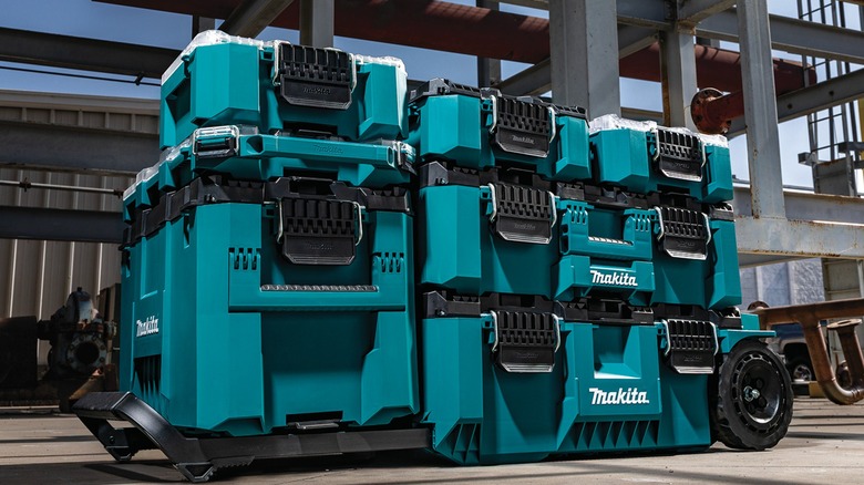 Blue Makita MakTrak storage cases stacked on a jobsite
