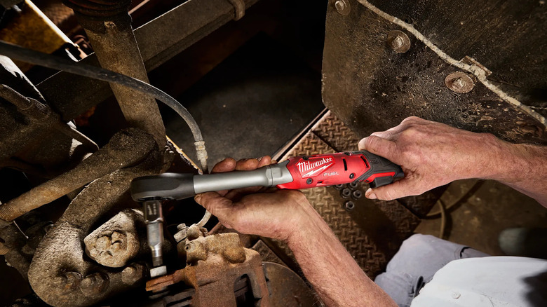 Man using extended ratchet with car