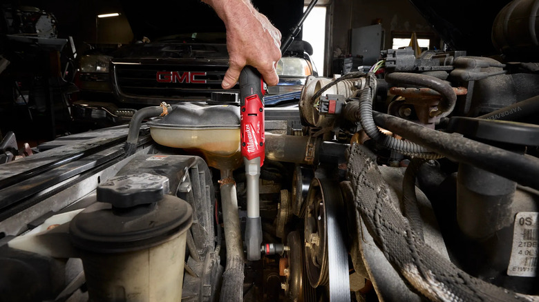 A person using extended ratchet with car