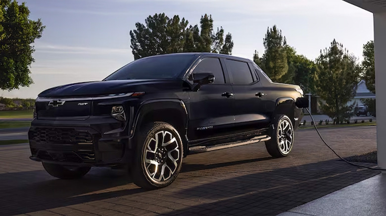 A black Chevy Silverado EV being charged