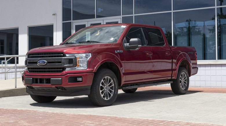 A red Ford F-150 on a dealership lot