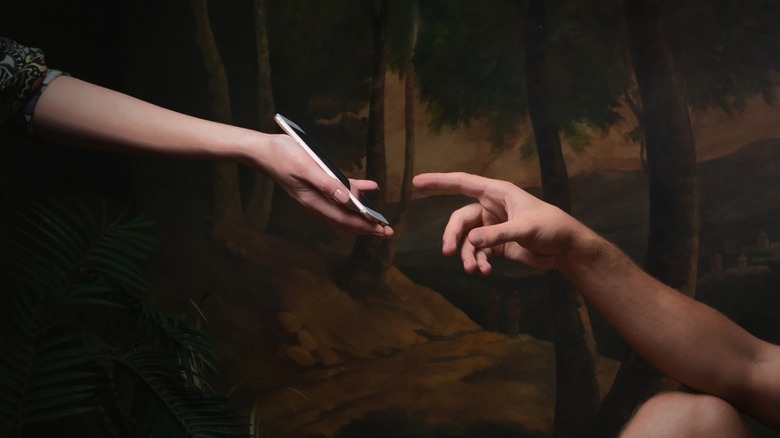 "Creation of Adam" hands with smartphone