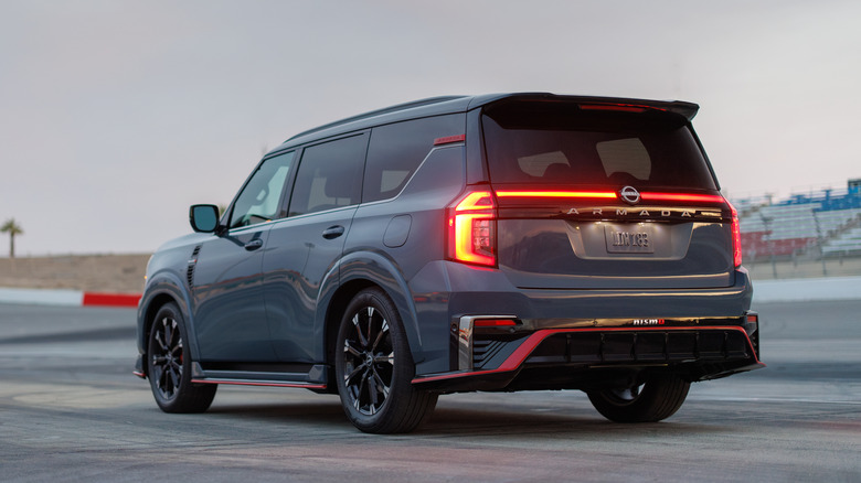 A gray Nissan Armada SUV parked in dim conditions with tail lights illuminated.