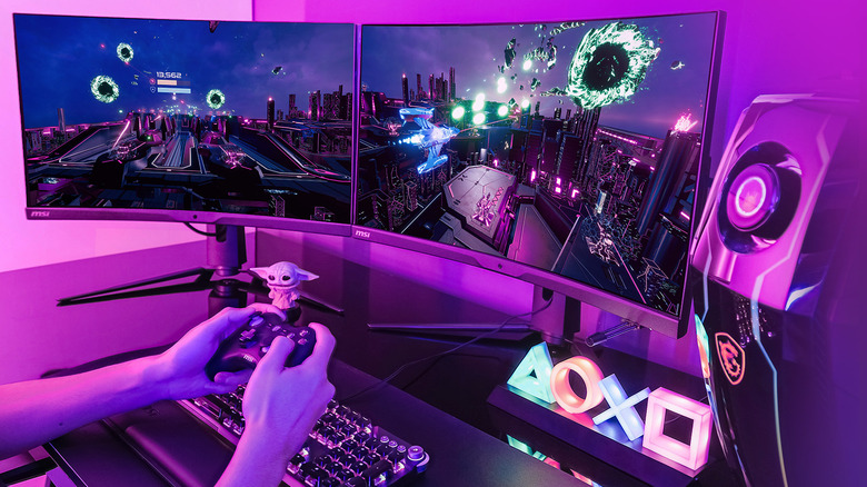 man plays game on his gaming pc with a multi monitor setup