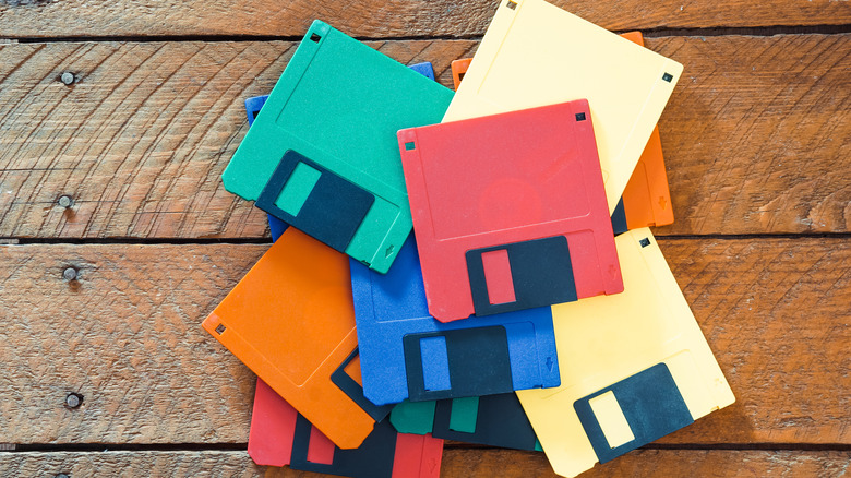 A stack of colored floppy disks on a wooden surface